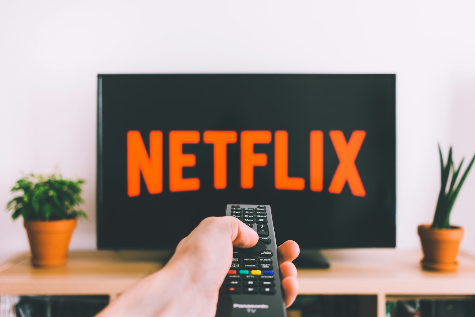 Person using remote to control smart TV